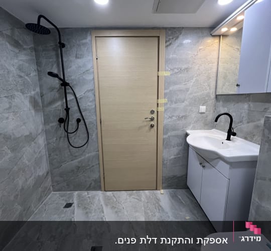 דלת עץ בחדר אמבטיה עם מקלחת וכיור
